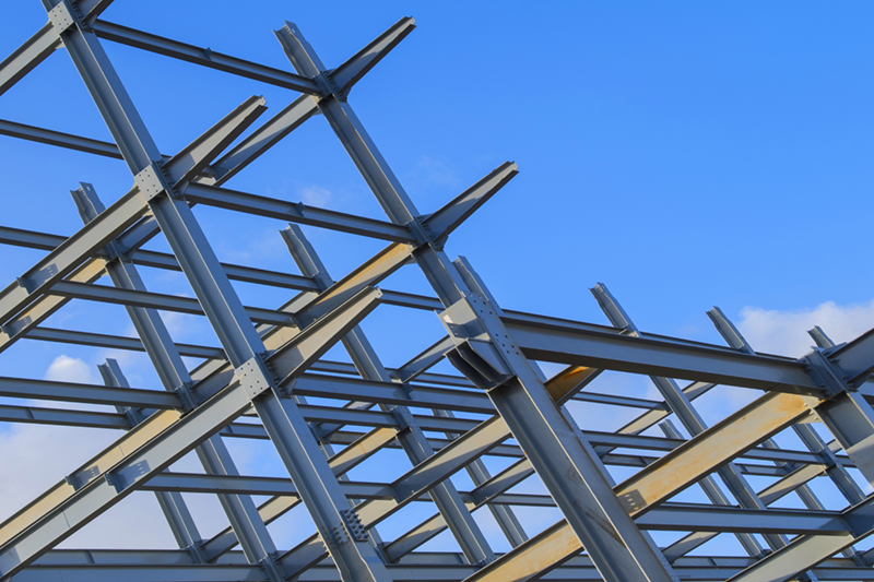 Steel framework of a building under construction against a blue sky